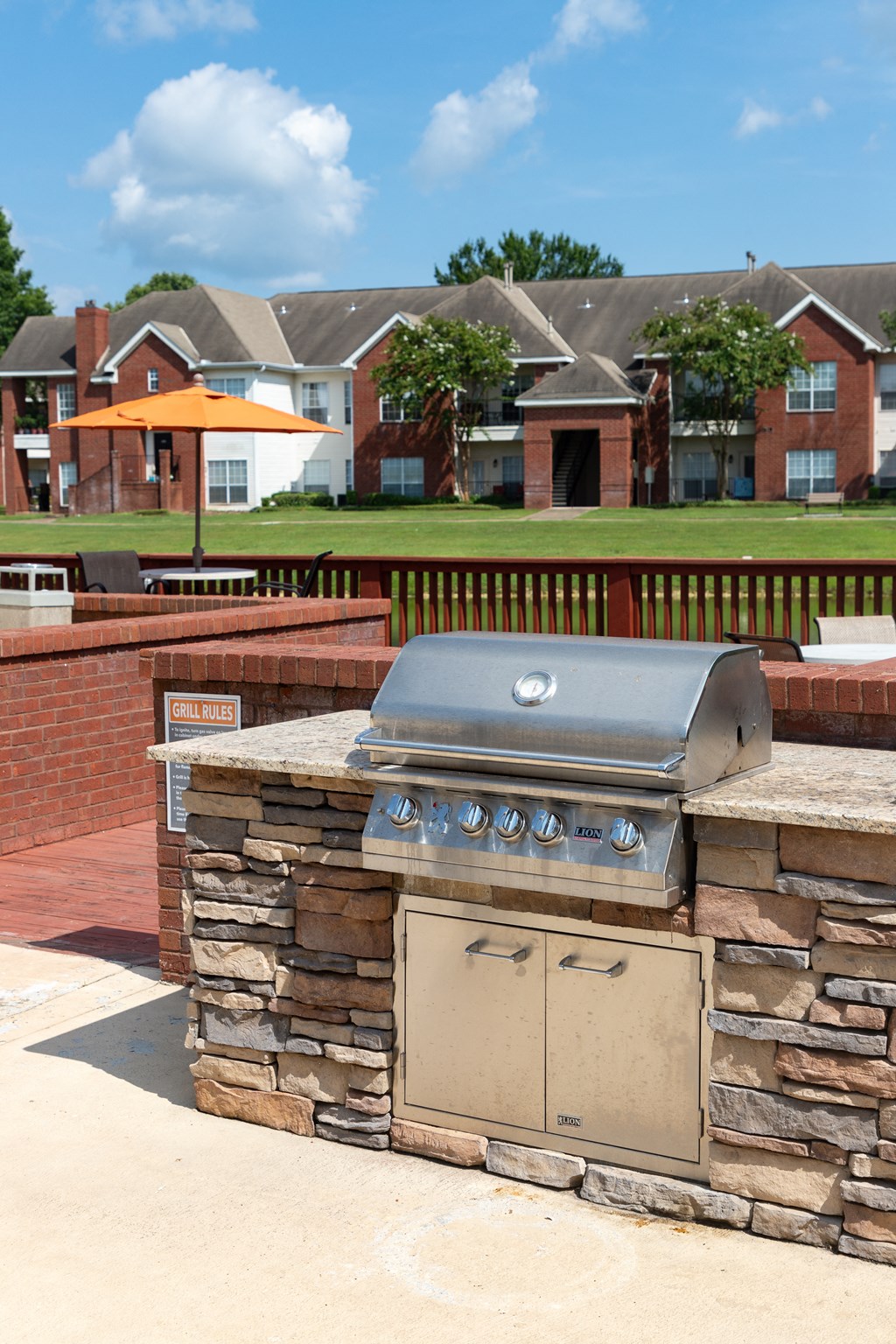 an outdoor grill in a backyard with houses in the background