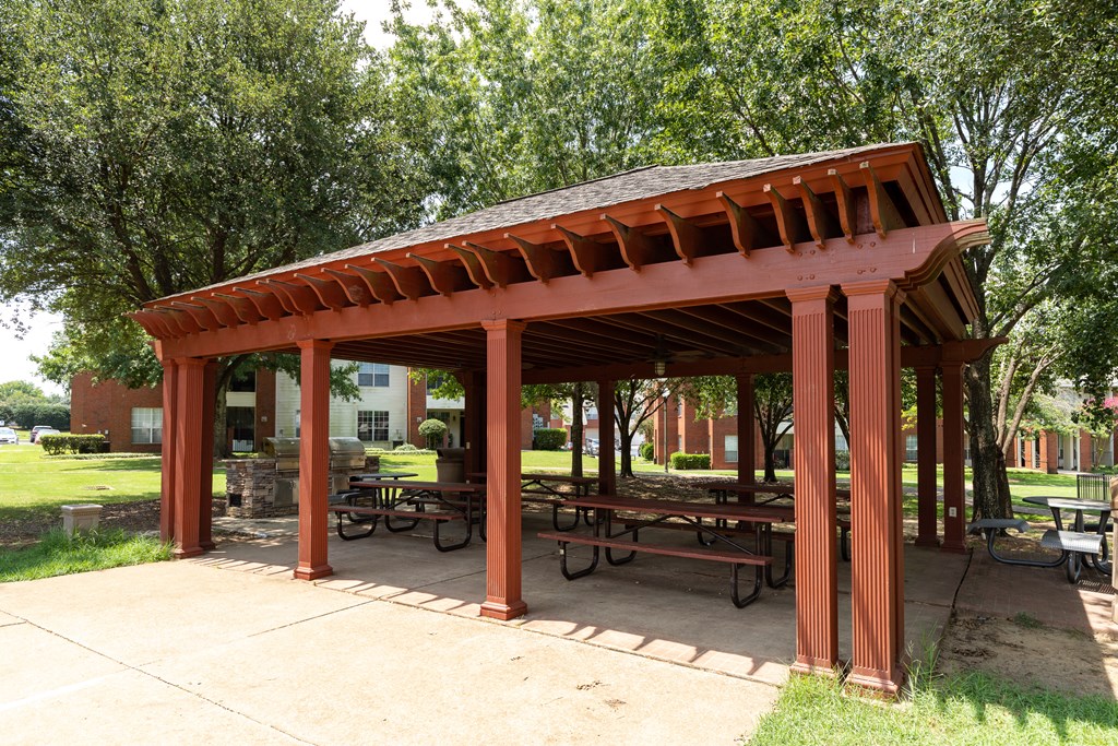 a pavilion with benches and trees in a park