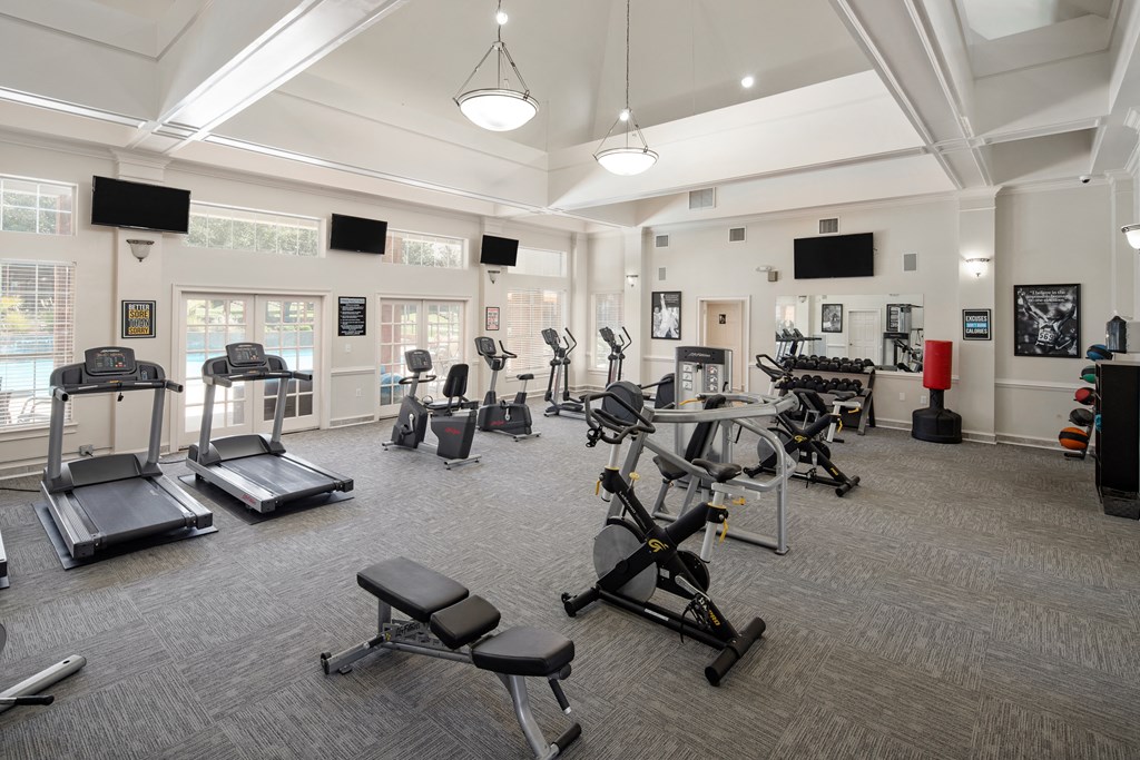 a gym with cardio machines and other exercise equipment in a large room