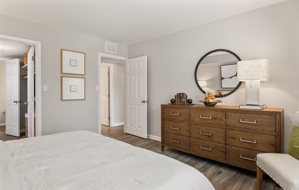a bedroom with a bed and a dresser with a mirror
