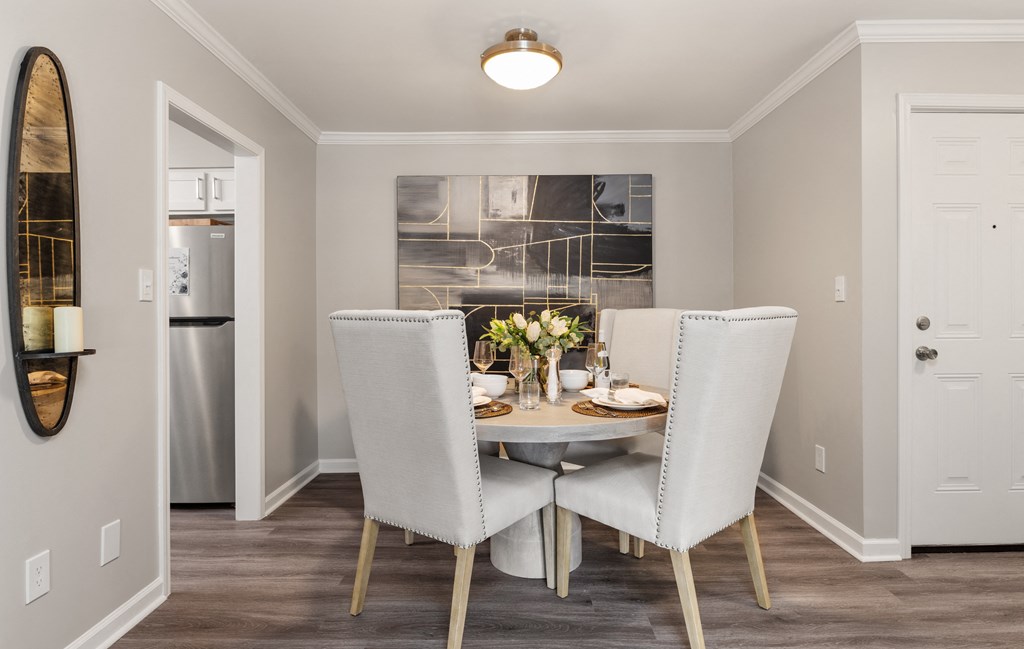 a dining room with white chairs and a table with flowers