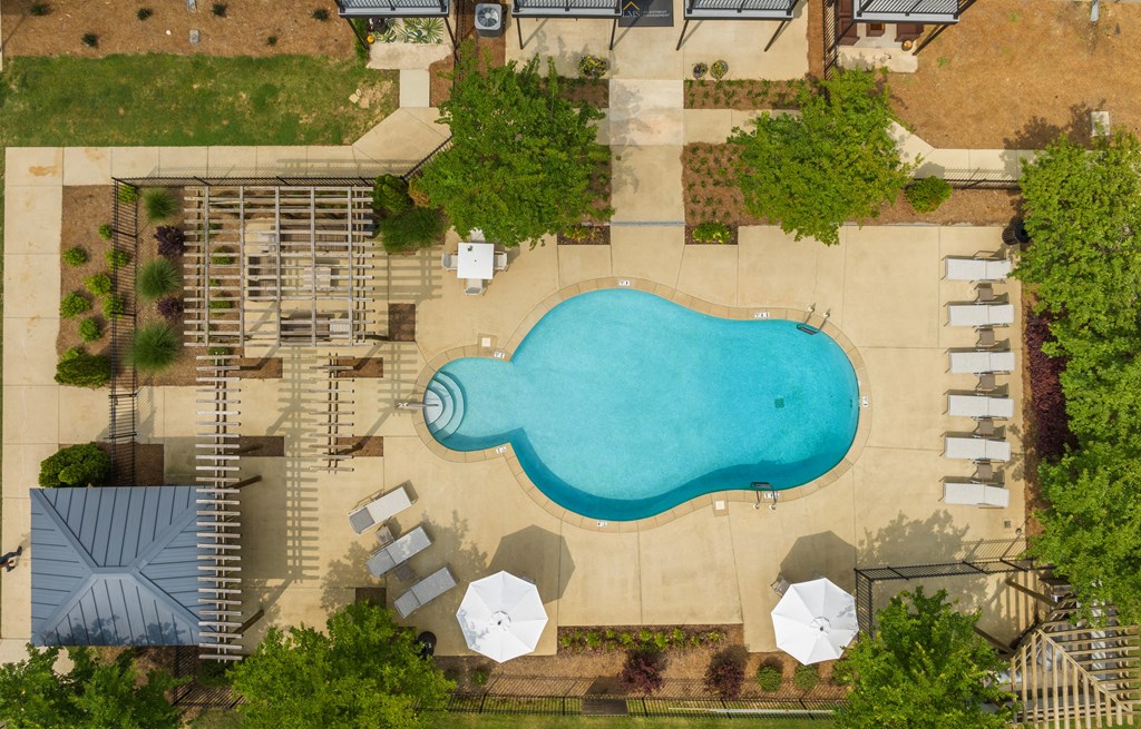 a birds eye view of a pool in a backyard with umbrellas