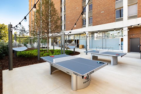 A ping pong table is in the middle of a patio area at Tower on Tenth Apartments, Birmingham 35205