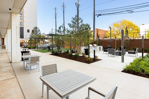 A patio with a table and chairs is surrounded by a garden at Tower on Tenth Apartments, Alabama, 35205