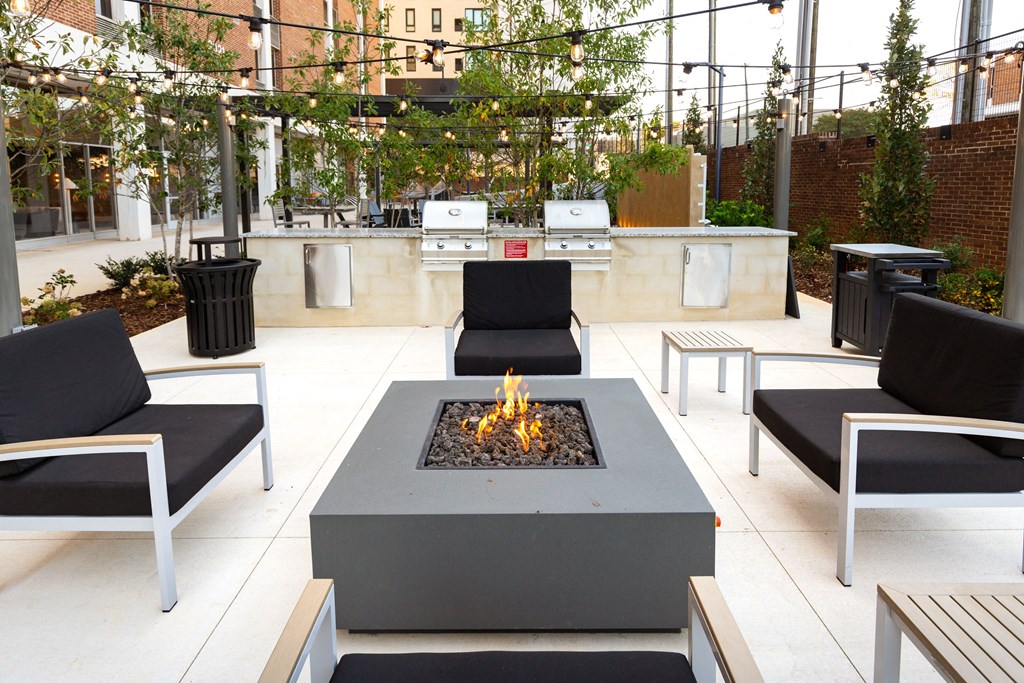 an outdoor patio with a fire pit and lounge chairs