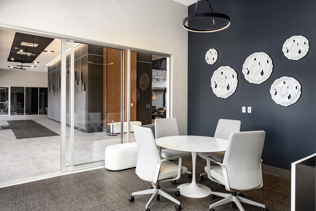 a dining room with a table and chairs and a blue wall with plates on it