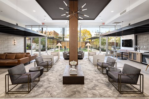 A modern living room with a long table and chairs at Tower on Tenth Apartments, Birmingham, Alabama