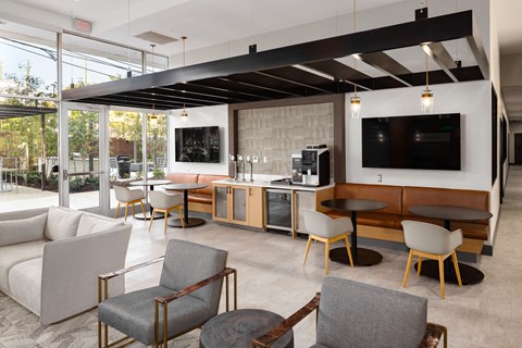A modern living room with a bar area and a television at Tower on Tenth Apartments, Birmingham 35205