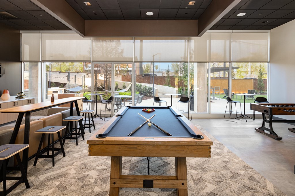a game room with a pool table and tables