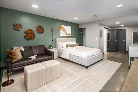 a bedroom with a bed and a couch in a room at Tower on Tenth Apartments, Birmingham, AL, 35205