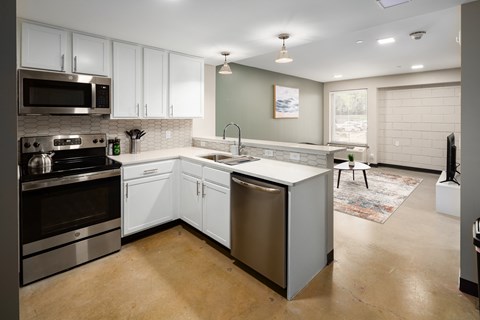 a kitchen with white cabinets and stainless steel appliances at Tower on Tenth Apartments, Birmingham 35205
