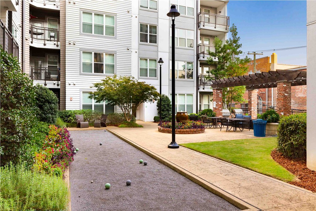 a walkway in front of an apartment building with a patio
