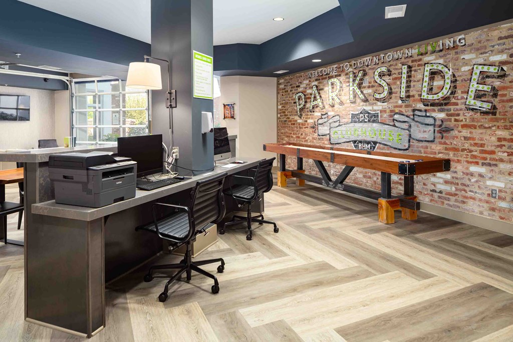 a renovated office space with a brick wall and a desk with a computer