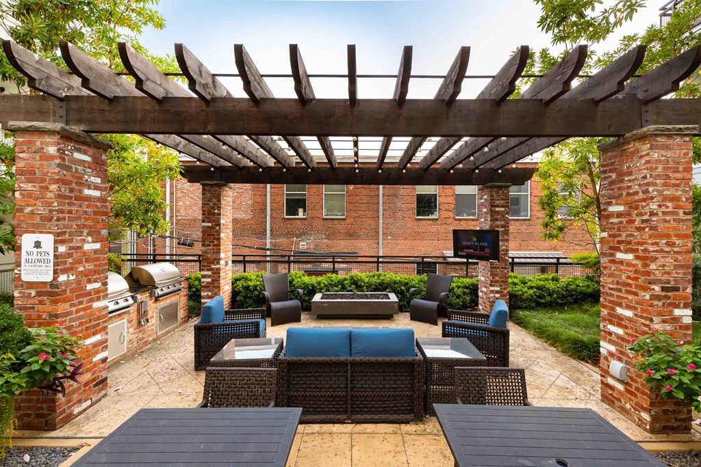 an outdoor patio with a fireplace and a pergola