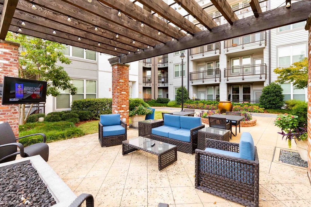 a patio with furniture and a tv in an apartment building