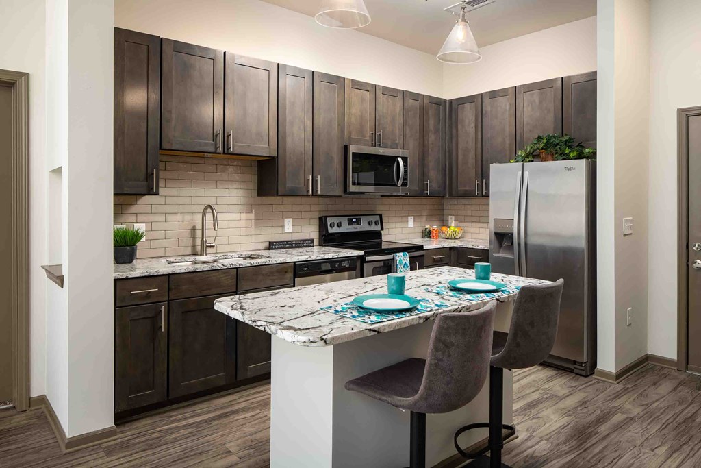 a kitchen with stainless steel appliances and a marble counter top