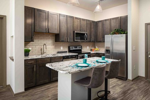 a kitchen with stainless steel appliances and a marble counter top