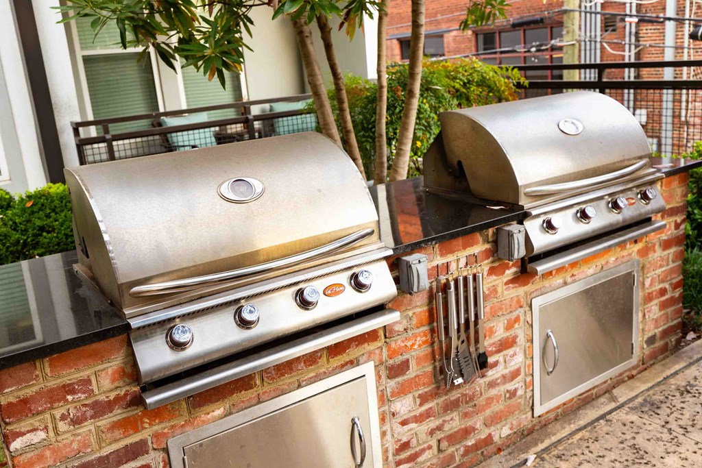 two grills on a brick wall in front of a house