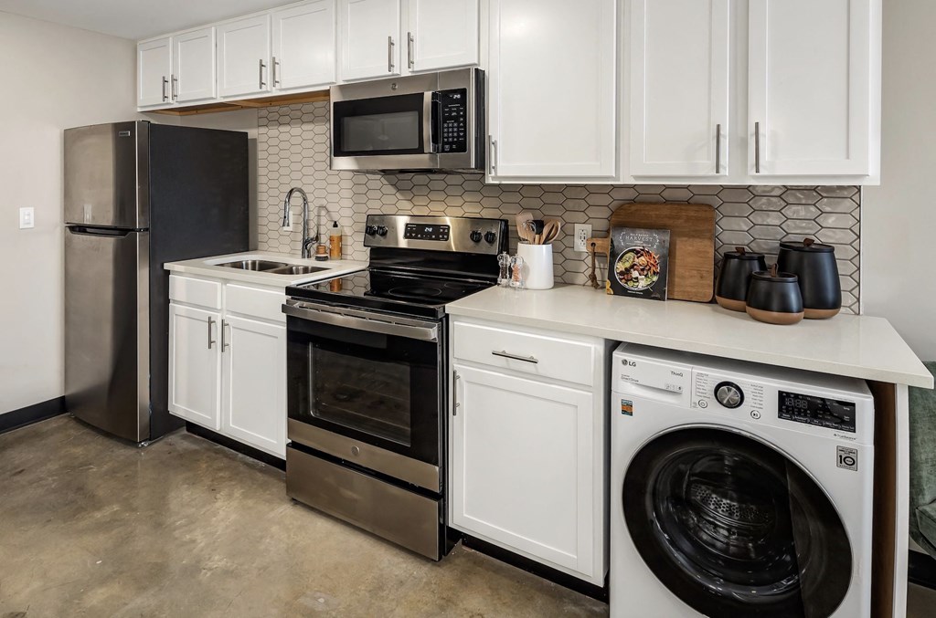 a kitchen with white cabinets and stainless steel appliances