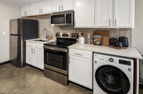 a kitchen with white cabinets and stainless steel appliances at Tower on Tenth Apartments, Birmingham, AL