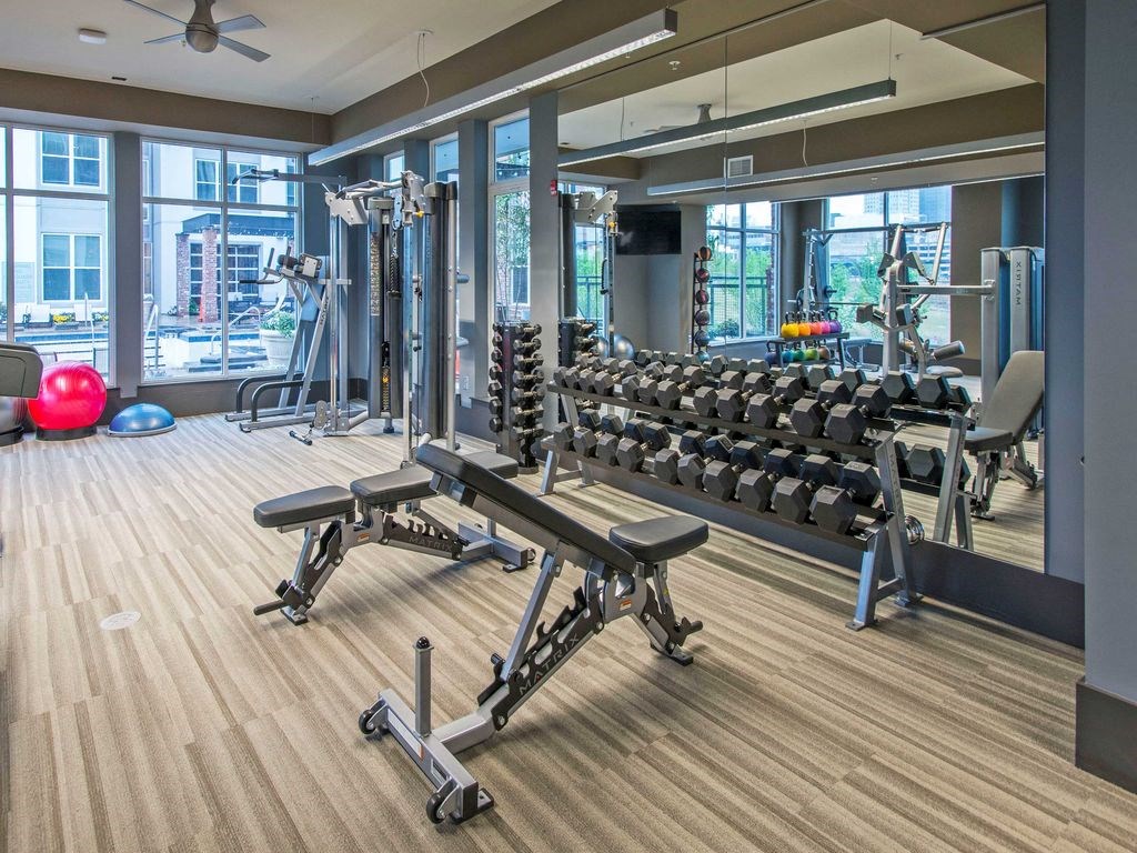 a gym with weights and a lot of windows