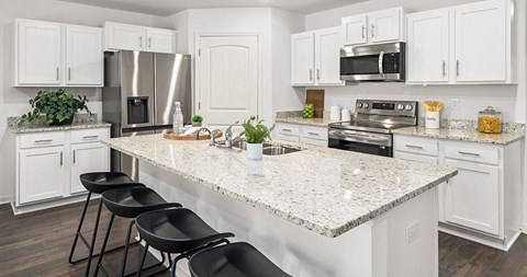 A kitchen with white cabinets and a granite countertop.