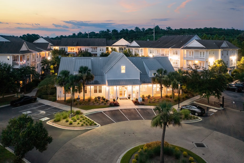 an aerial view of a building with palm trees at dusk