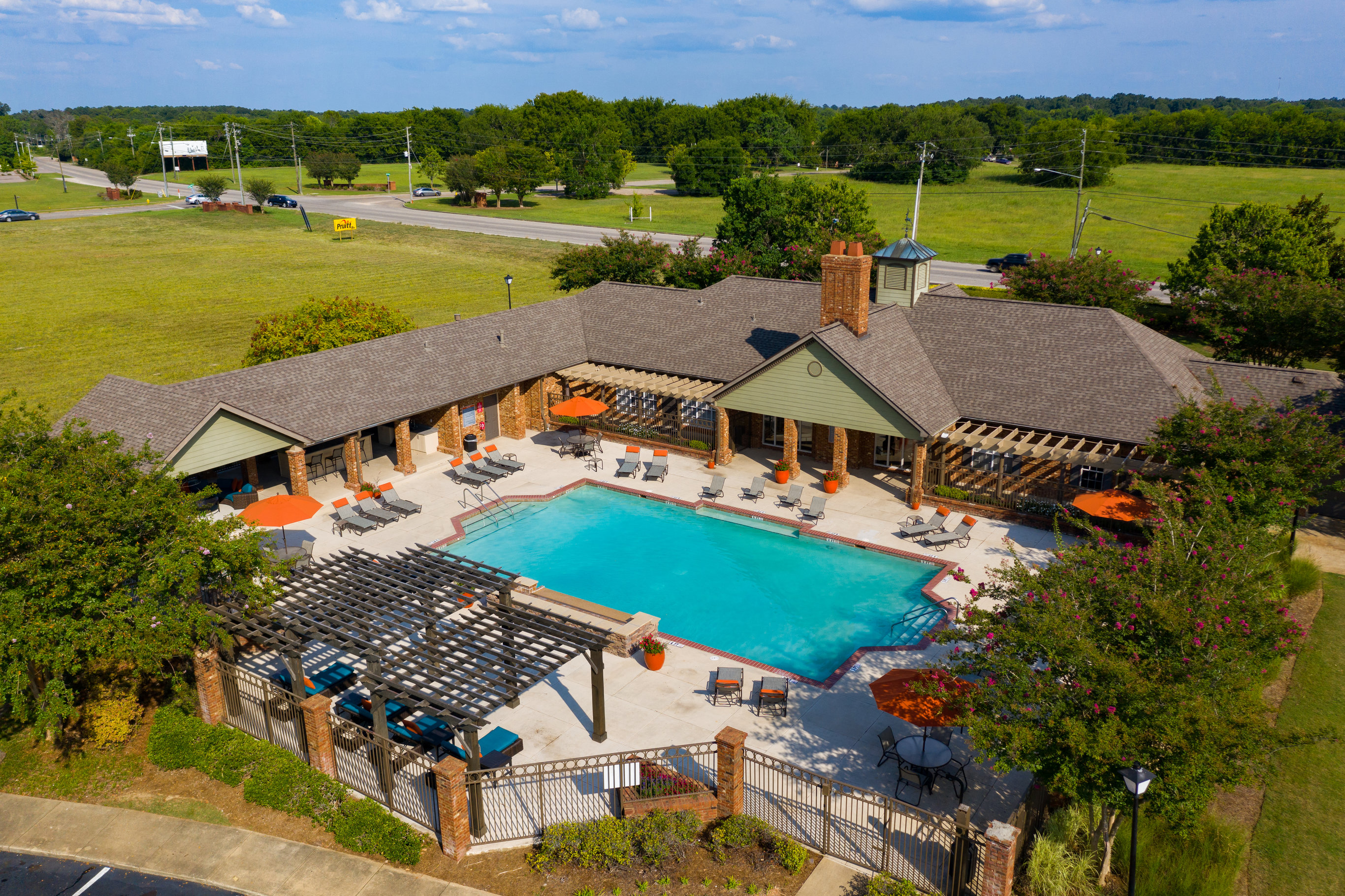 an aerial view of a swimming pool with a pavilion and a resort style building