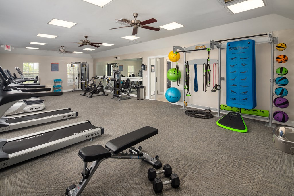 a gym with treadmills and other exercise equipment at the enclave at university crossings