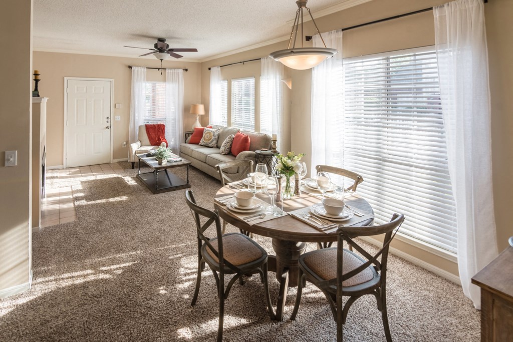 a living room and dining room with a table and chairs