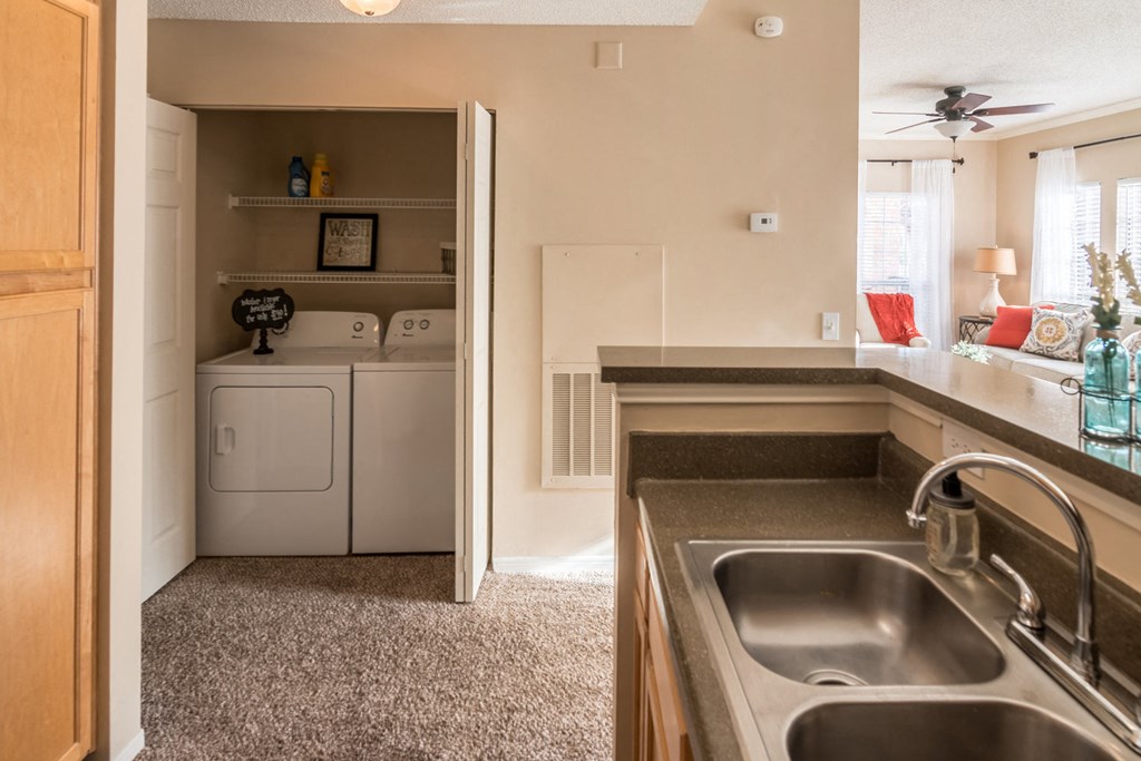 the view from the kitchen into the laundry room and the living room