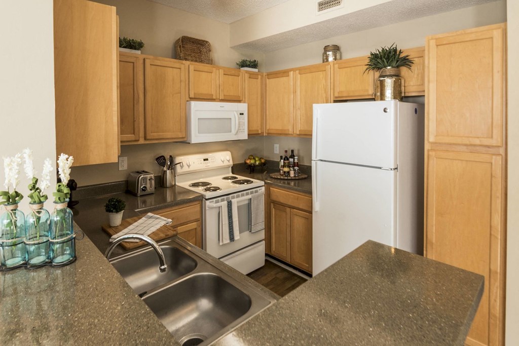 a kitchen with white appliances and wooden cabinets