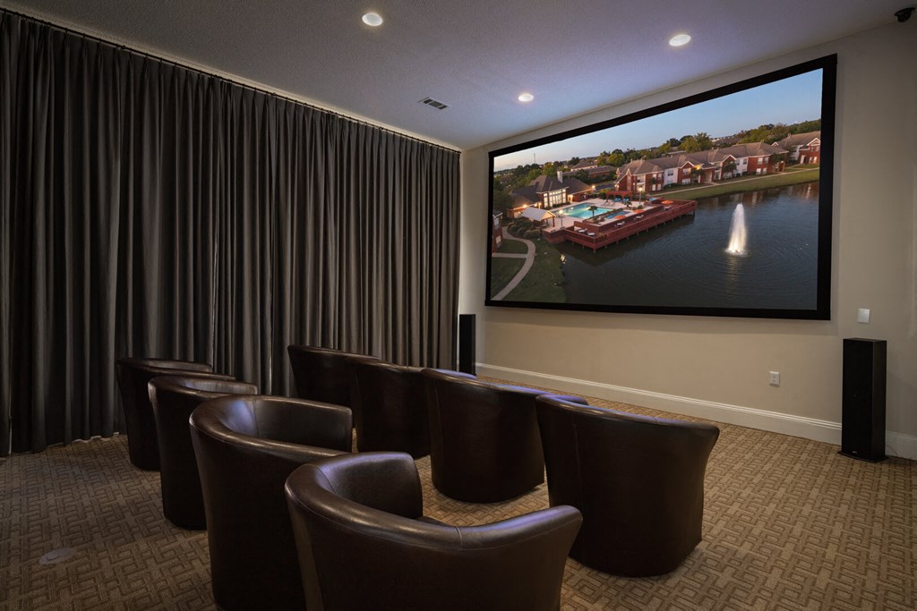 a screening room with leather chairs and a large screen tv