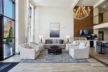 a living room with white furniture and a large window