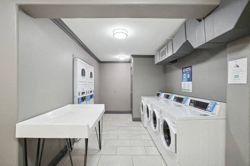 a laundry room with a row of washing machines