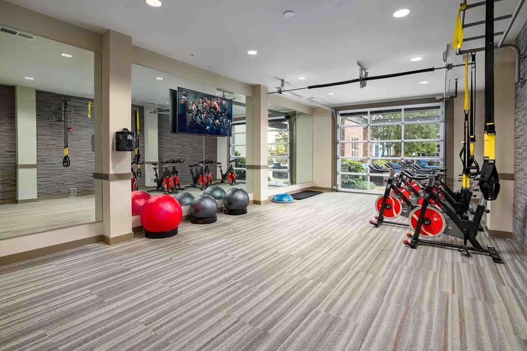 a gym with weights and other exercise equipment in a large room with a large window