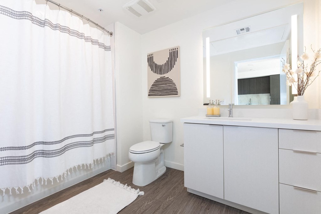 a white bathroom with a shower and a toilet