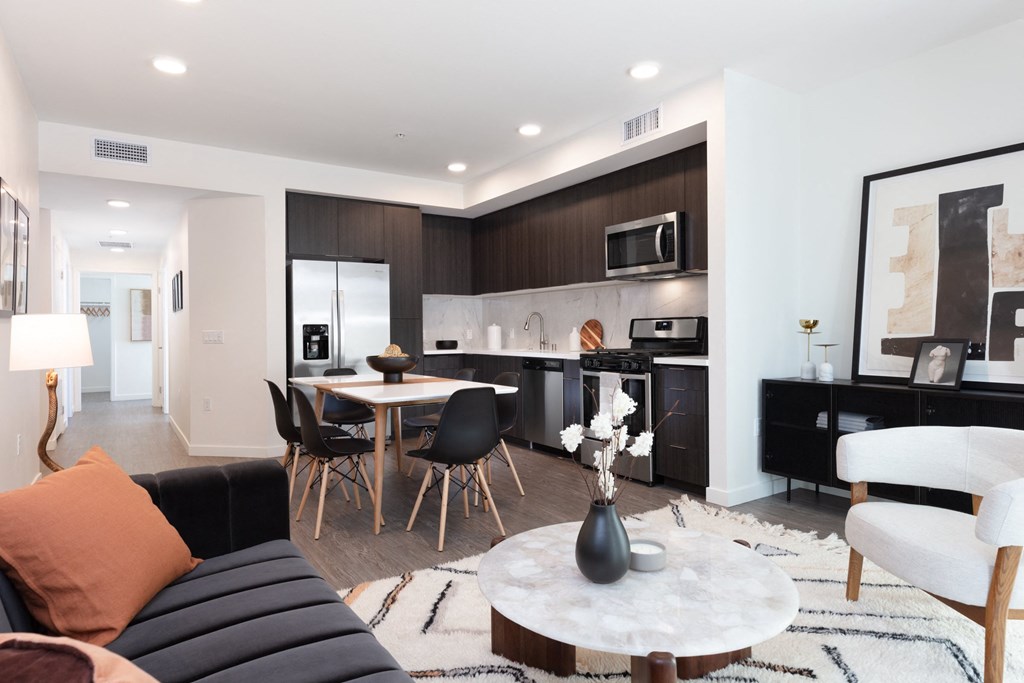 a living room and kitchen with a table and chairs