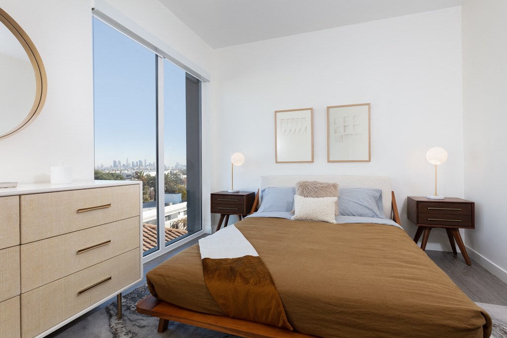 a bedroom with a bed and a large window