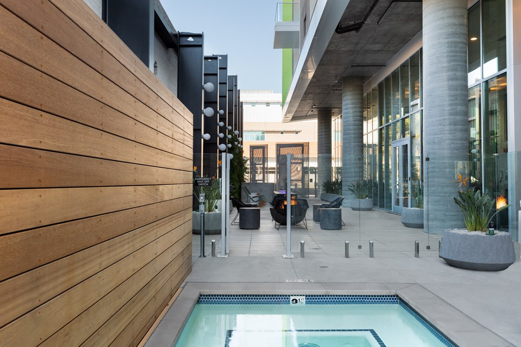 a pool is next to a building with a wooden wall