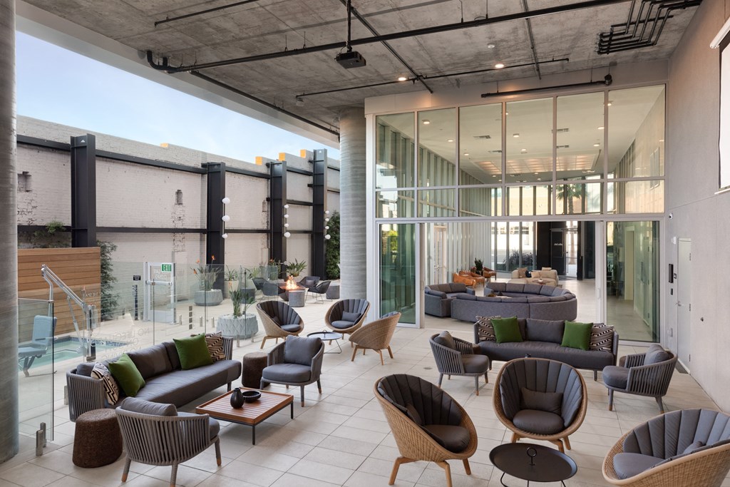the lobby of a hotel with couches and chairs and a pool