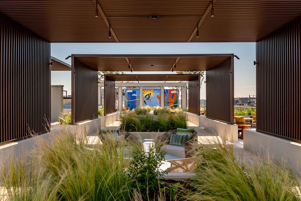 a view of the roof deck with a seating area and a mural on the wall
