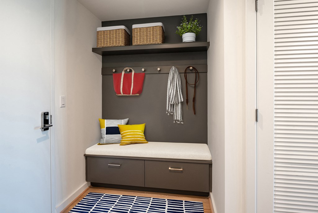 a built-in mud nook with a bench, shelf, and hooks