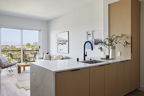 A kitchen with a marble countertop and wooden cabinets.
