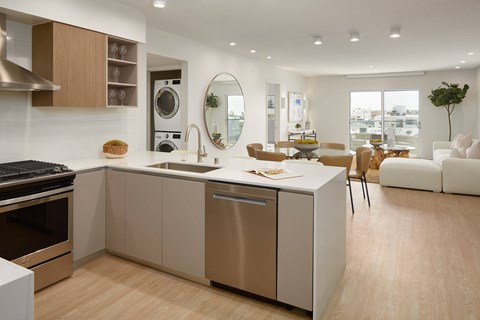 A modern kitchen with a large island and a view of the city.