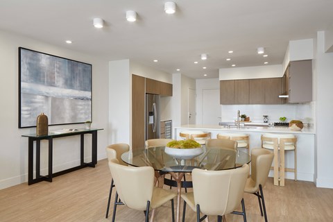 A modern dining room with a glass table and chairs.