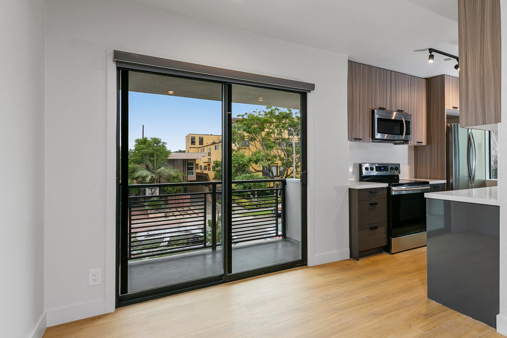 a kitchen with a sliding glass door leading to a balcony