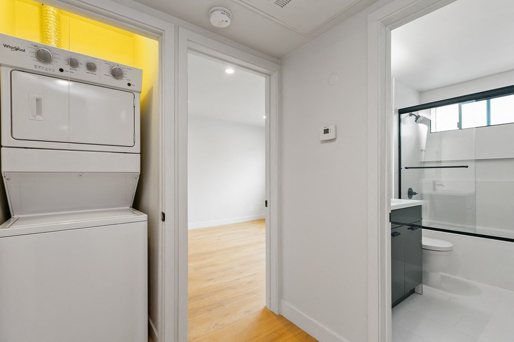 a laundry room with a washer and dryer and a door to a bathroom