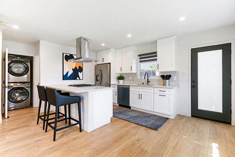 A kitchen with a white counter and a bar stool.