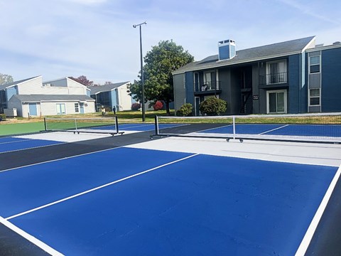 A tennis court with a blue surface and white lines.